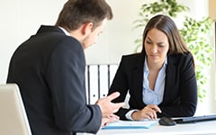 Bad businessman trying to convince to a suspicious client during a difficult negotiation in a desktop at office