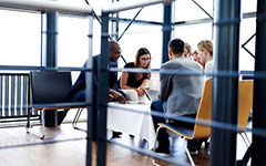 Group of executives sitting and working together using tablets and laptop